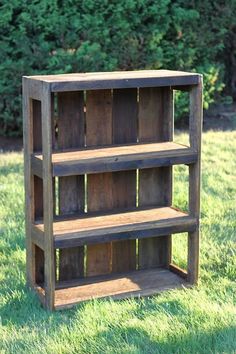 an old wooden bookcase sitting in the grass