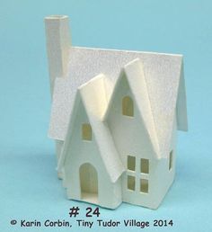 a paper model of a white house on a blue background with the words karn corbin, tiny tudor village 2014