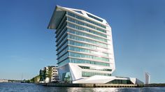 a tall building sitting on top of a body of water next to a large white boat