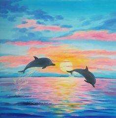 two dolphins jumping out of the water at sunset