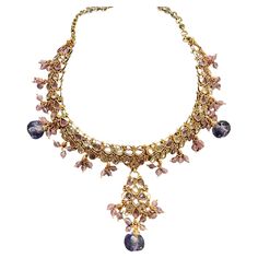 Add a touch of luxuriousness to your look with the Egyptian necklace. This ornate choker features an exquisite handmade design, delicately crafted using color to create a truly unique piece. Wear it day or night for a glamorous finish every time. Egyptian, jeweled necklace ornate with handmade tooling, beads, pear-shaped lavender, and pink-colored stones. The pendant is adjustable for length at 16" and can be reduced for a choker. The wide pattern consists of mesh that extends 2.25." long. A combination of color and beads dangle and enhance the look. Enameling and other pear-shaped stones are displayed at the top rim of the necklace. The material is a brass base with heavy 24k gold electroplating. The chain is adjustable and is 16" in length. Enameling on some bezels and scrolling. Circa 2 Egyptian Motifs, Jeweled Necklace, Egyptian Necklace, It Day, Color Lavanda, Colored Necklace, Jewel Necklace, Colored Stones, Long A