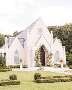 a white church surrounded by hedges and flowers