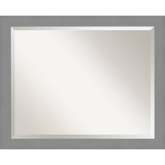 a white framed mirror sitting on top of a wall