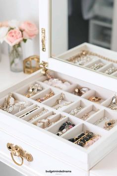 a white dresser with drawers filled with jewelry