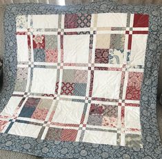 a blue and red patchwork quilt sitting on top of a couch