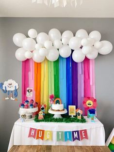 a rainbow themed birthday party with balloons and cake