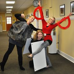 three women are posing with giant letters in an office