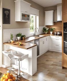 a kitchen with white cabinets and wooden counter tops, along with fruit on the table