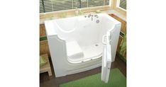 a white bath tub sitting inside of a bathroom next to a green carpeted floor