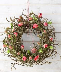 a wreath with pink flowers hanging on a wall