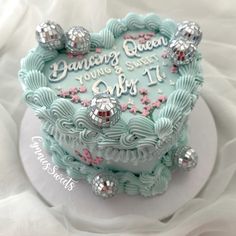 a birthday cake decorated with blue icing and pink flowers on a white tablecloth