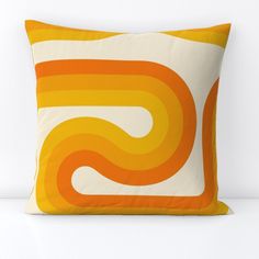 an orange and yellow pillow on a white surface with the letter s printed on it