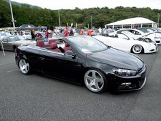 a black convertible car parked in a parking lot