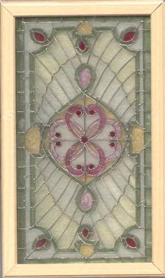 an art nouveau stained glass window with pink and white designs on the bottom, surrounded by gold trim