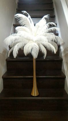 a tall white palm tree sitting on top of a set of stairs