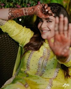 a woman wearing a yellow outfit and holding her hands up