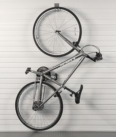 a bicycle hanging from the side of a garage door in front of a white wall