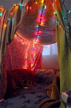 a bed covered in colorful lights and curtains