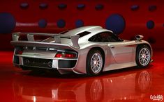 a silver sports car parked on top of a red floor