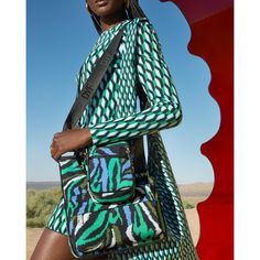 a woman is holding a handbag while standing in the desert