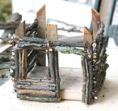 a wooden frame made out of branches and nails on top of a white countertop