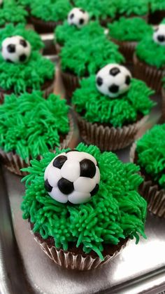 cupcakes with green frosting and soccer balls on them