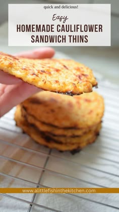 A hand holds a single cauliflower sandwich thins so that the side of it can be seen. A stack of four sandwich thins is sitting on a cooling rack in the background, slightly blurred. Cauliflower Flat Bread, Outer Isle Cauliflower Thins Recipes, Cauliflower Flatbread Recipes, Calibrate Diet Recipes, Cauliflower Thins Optavia, Cauliflower Wraps Recipe, Califlower Hashbrowns, Cauliflower Rounds, Cauliflower Pita