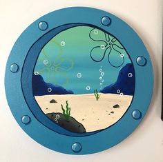 a blue porthole with an octopus and seaweed in the water on it's side