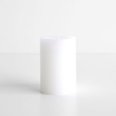 a white candle sitting on top of a table