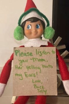 an elf holding a sign that says please listen to your mom