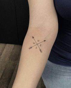 a woman's arm with an arrow tattoo on it