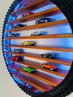 toy cars are lined up on wooden shelves in the shape of a wheel rimed display case