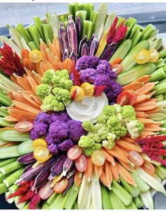 a bunch of different colored vegetables arranged in the shape of a wreath on top of a car