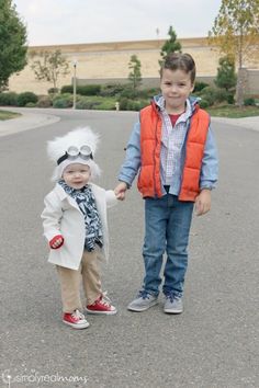 two small children are holding hands in the street