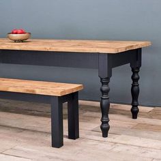 a wooden table with two benches and a bowl of fruit on the table next to it