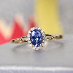 a tan gold ring with a blue and white diamond in the center on a table