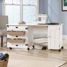 a room with blue walls and white furniture in the corner, including a desk that has several drawers on it