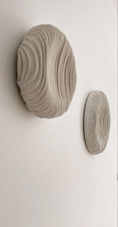 two sculptures are shown on the wall next to each other, one is made out of clay