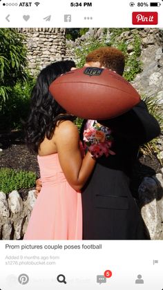 a man and woman kissing with a football on their head