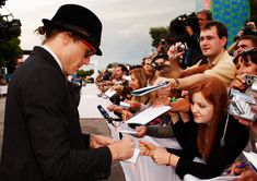 the man is signing autographs for fans