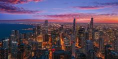 an aerial view of the chicago skyline at night with lights on and skyscrapers lit up