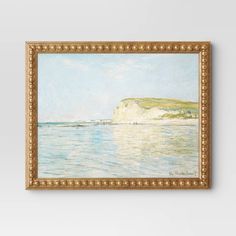 a painting hanging on the wall next to a white wall with a gold frame and an ocean scene