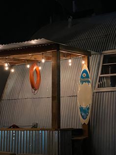 there is a surfboard hanging from the side of a building with lights on it