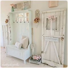 a white bench sitting next to a wall with flowers on it's headboard