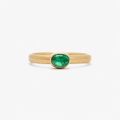 a gold ring with an oval green stone