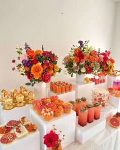 an assortment of desserts and flowers on display in vases at a wedding reception