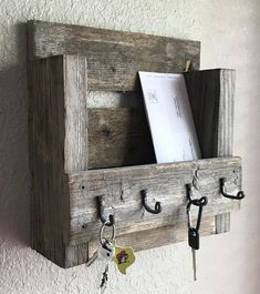 a wooden shelf with hooks and keys hanging from it's sides on the wall