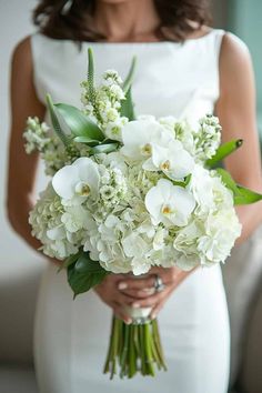 a woman holding a bouquet of white flowers