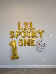 balloons are arranged on the wall to spell i'll spooky 1st birthday