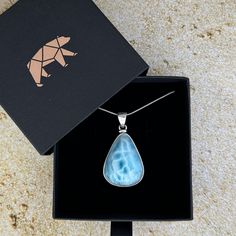 The most beautiful gemstone found only in the Dominican Republic, Larimar is a stone of coolness and calm, much like the native waters it resembles. Larimar is a powerful healer! It can help with panic attacks, anger, fear and other stress-related issues. Secure this unique and beautiful one-of-a-kind incredible Larimar pendant around your neck and breathe in the calm of the Caribbean ocean! AA Grade Includes an 18” sterling silver chain Lead-free; nickel-safe Set in 925 sterling silver Pendant is approximately 1.82”H (46.3mm) x 1”W (26mm) Comes in our exclusive luxury gift box Source: Dominican Republic Any visible imperfections and/or cracks are due to natural formation Product color may slightly vary due to photographic lighting sources! Disclaimer: Crystals should not be swallowed, giv Caribbean Ocean, Orange Stone, Larimar Pendant, Book Jewelry, The Dominican Republic, Clear Stone, Purple Stones, Luxury Gift Box, Stirling